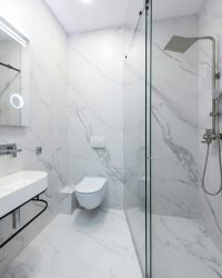 pexels-photo-6444245-6444245 Sleek and modern bathroom interior featuring elegant marble walls and a glass shower.